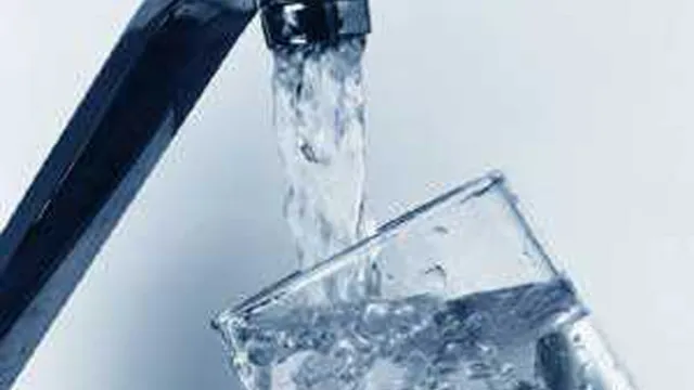 Bicchiere riempito d'acqua sotto il rubinetto