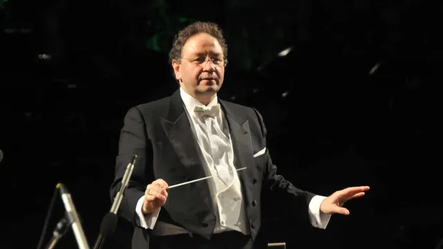 Diretto d'orchestra in attività, fotografia a mezzo busto su sfondo nero