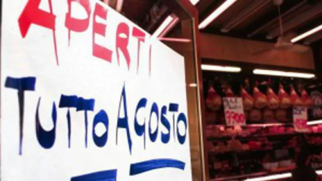 foto di negozio con cartello di apertura ad agosto