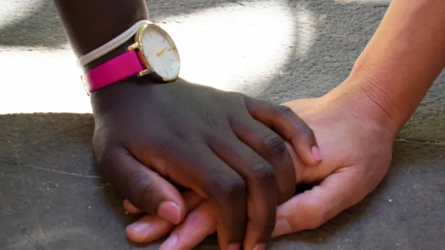 mano bianca e mano nera che si intrecciano